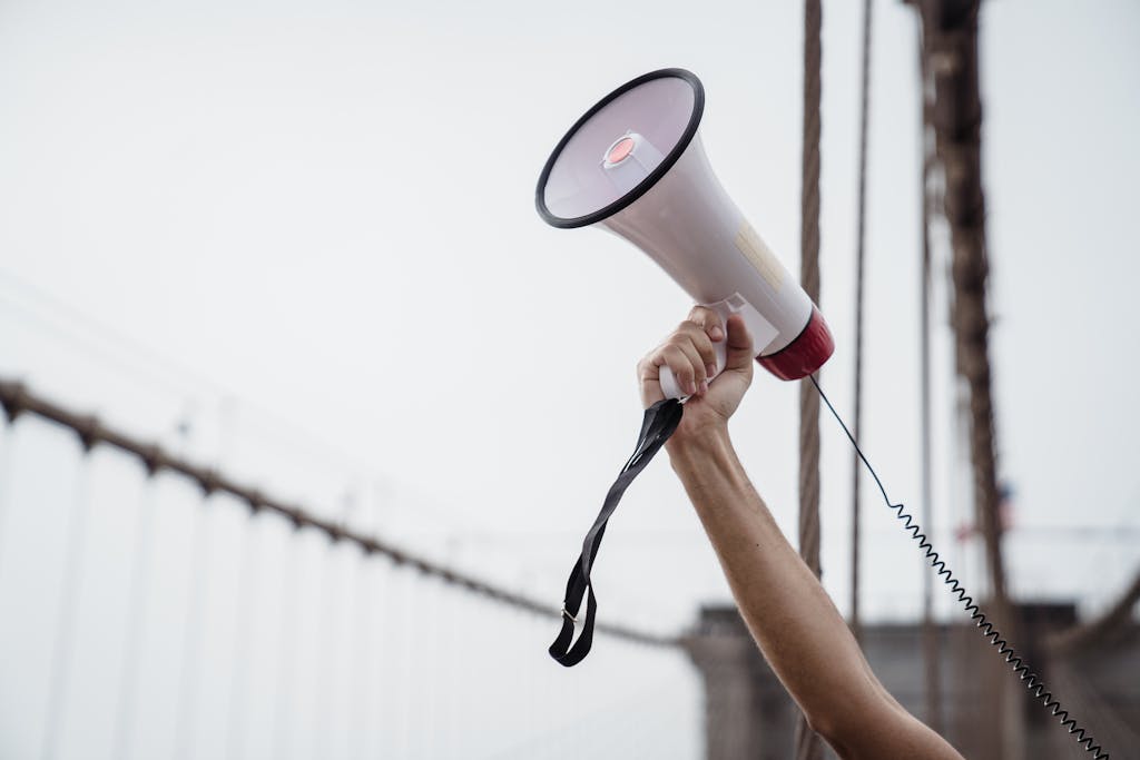 Person Holding White and Black Megaphone